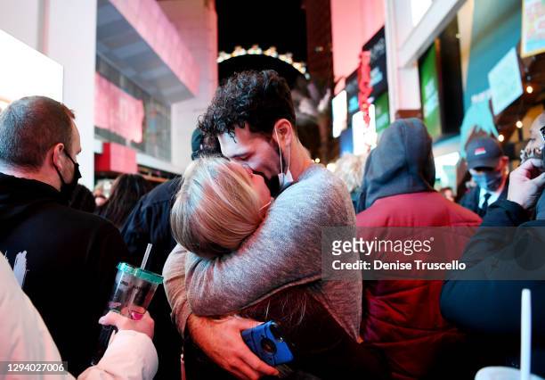 Young couple kiss with their masks pulled down during a New Years Eve celebration on the Las Vegas strip on December 31, 2020 in Las Vegas, Nevada.