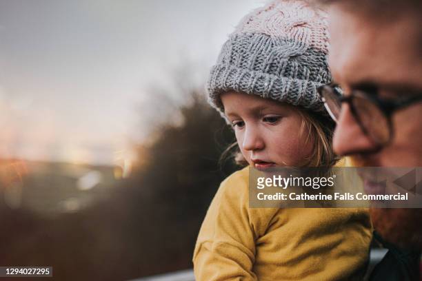 father holding daughter outdoors - guarding stock-fotos und bilder