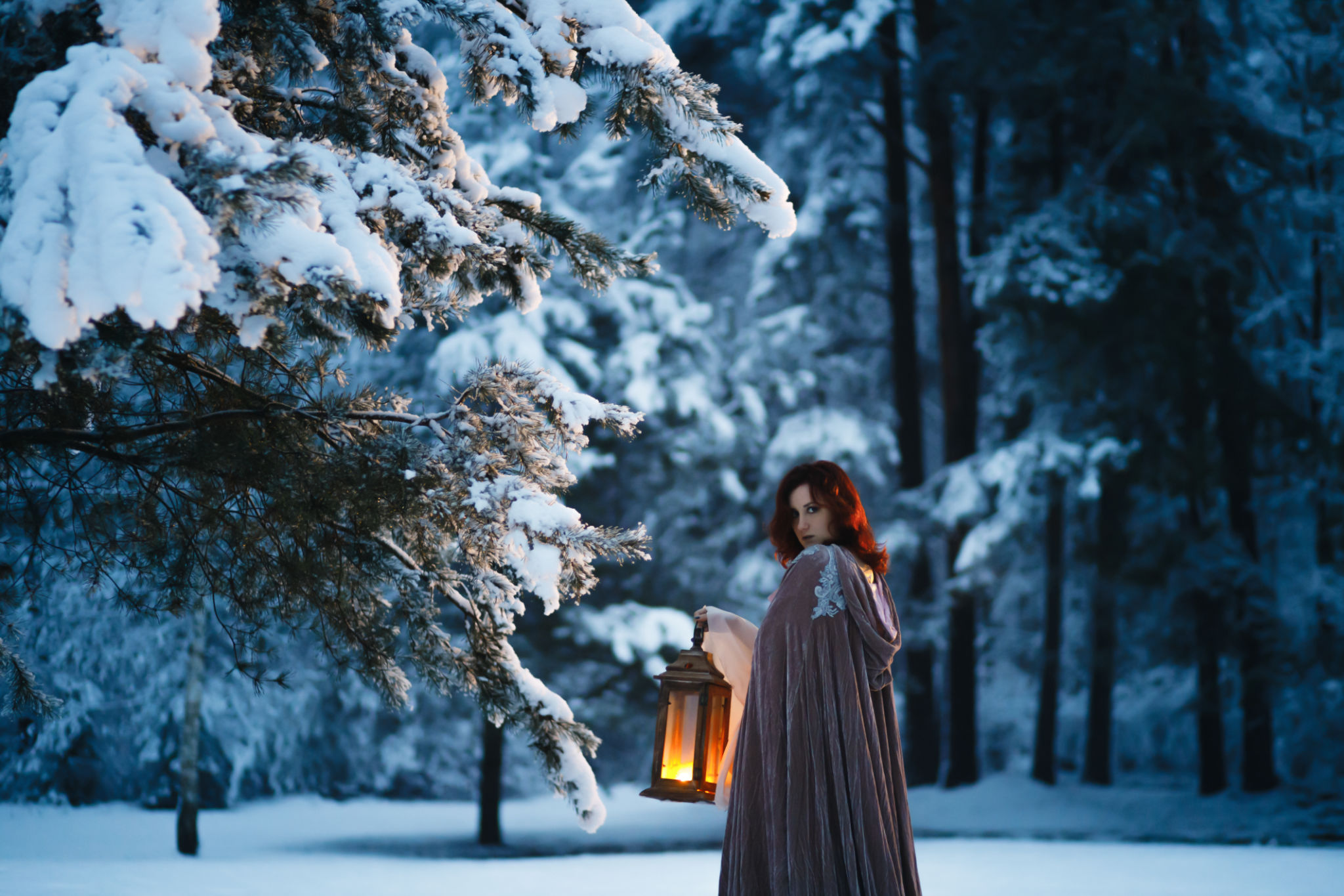 Fantasy cosplay: Young woman with vintage lantern looking at fir tree covered in snow. Medieval fairytale concept Fantasy cosplay: Young woman with vintage lantern looking at fir tree covered in snow. Medieval fairytale concept