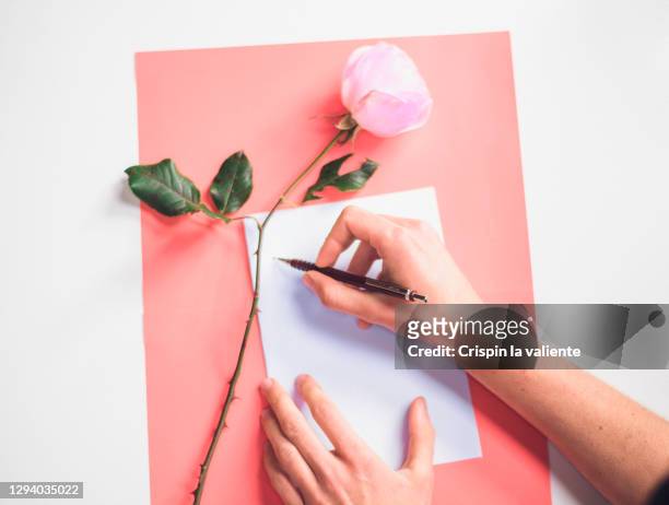 a hand writing a love letter with pink background - hand written letter ストックフォトと画像