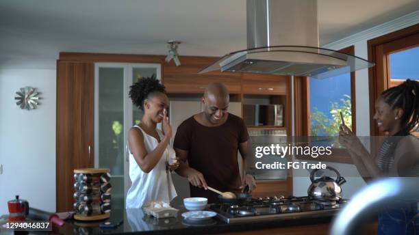 het meisje dat van de tiener ouders filmt die thuis koken - modern family media call stockfoto's en -beelden