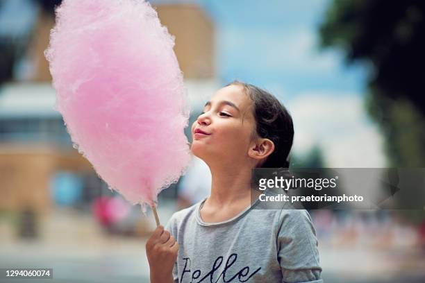 porträtt av liten flicka äta sockervadd - carnival bildbanksfoton och bilder