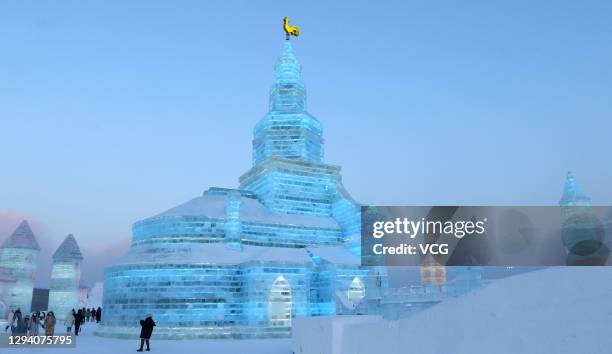 Tourists look at illuminated ice sculptures at the 22nd Harbin Ice and Snow World before the 37th Harbin International Ice and Snow Festival on...