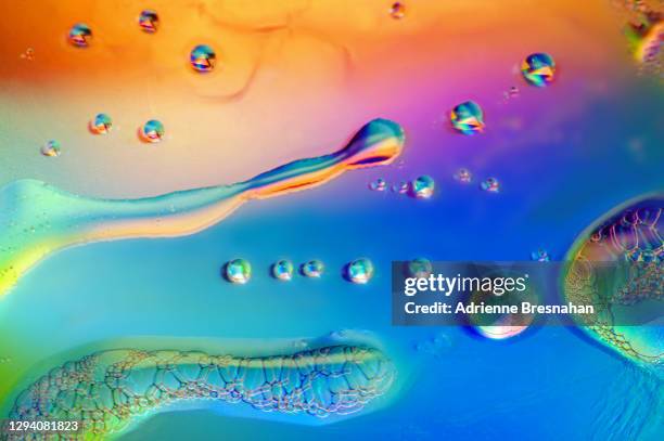 liquid splattered on holographic foil - changing colour stock pictures, royalty-free photos & images