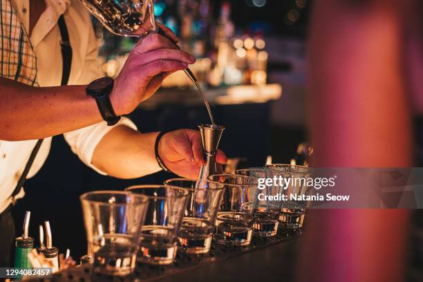 bar tender hands pouring drinks - shot alcool photos et images de collection