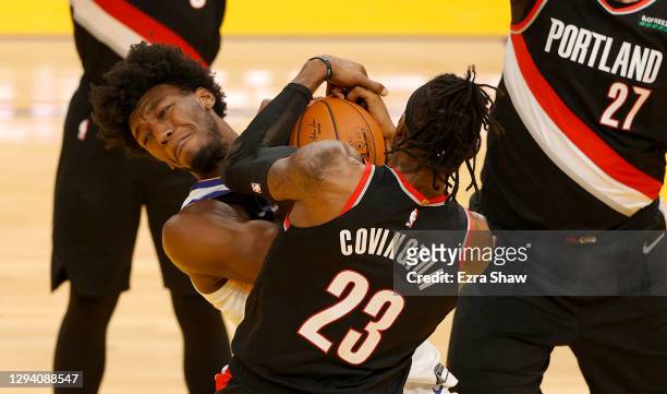 James Wiseman of the Golden State Warriors and Robert Covington of the Portland Trail Blazers go for a loose ball at Chase Center on January 01, 2021...