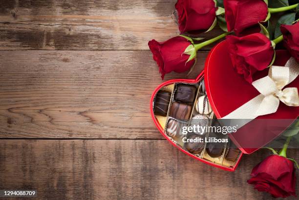 valentijnsdag doos van chocolade en rode rozen - chocolate heart stockfoto's en -beelden