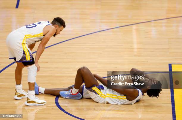 Stephen Curry checks on James Wiseman of the Golden State Warriors after Wiseman injured himself during the fourth quarter of their game against the...