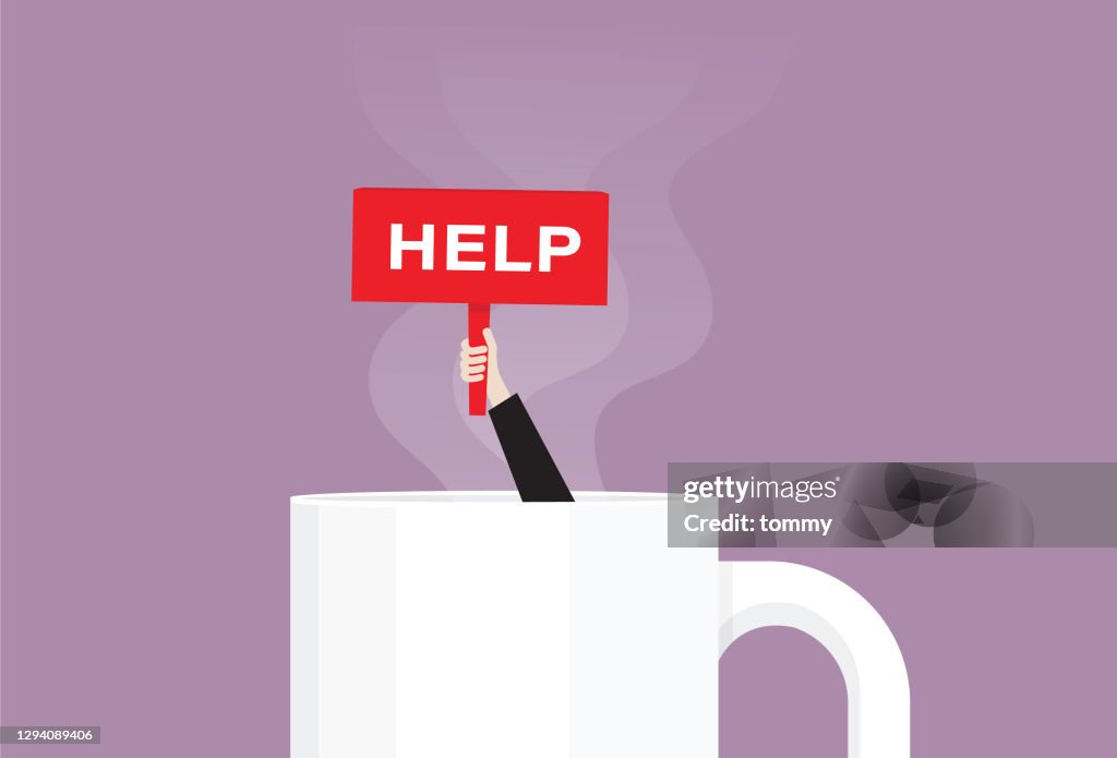 Hand holds a help sign in a coffee cup