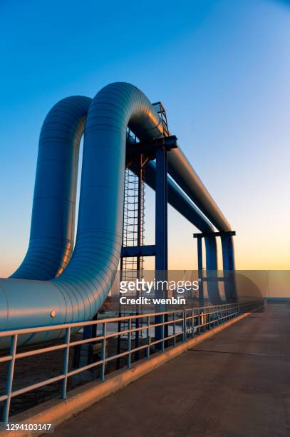 blue pipes going to oil refinery - oil refinery stock pictures, royalty-free photos & images