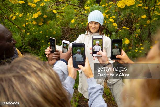 photo call! a beautiful hiker poses in green nature wearing her baby blue beanie and surrounded by yellow blossoms - the forest photocall ストックフォトと画像