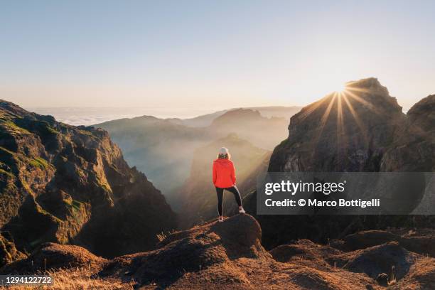 tourist admiring the sunset from the top of a mountain in madeira - landschaft rot stock-fotos und bilder