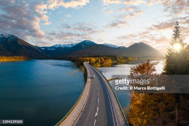 car driving on idyllic bridge over sylvenstein lake, germany - landschaft stock-fotos und bilder