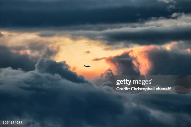 an airliner throughout stormy clouds in normandy, france - flugzeug stock-fotos und bilder