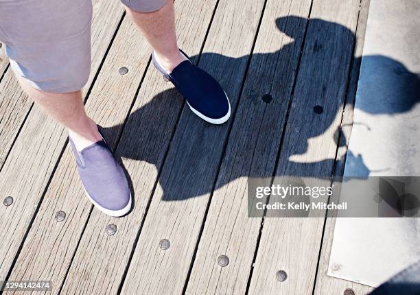 man on pier with shadow - pier 1 stock pictures, royalty-free photos & images