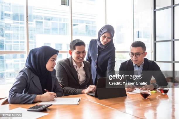 business man and woman in meeting room - malay hijab stock pictures, royalty-free photos & images