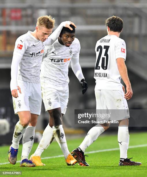 Breel Embolo of Moenchengladbach celebrates his team's first goal with teammates Oscar Wendt and Jonas Hofmann during the Bundesliga match between...