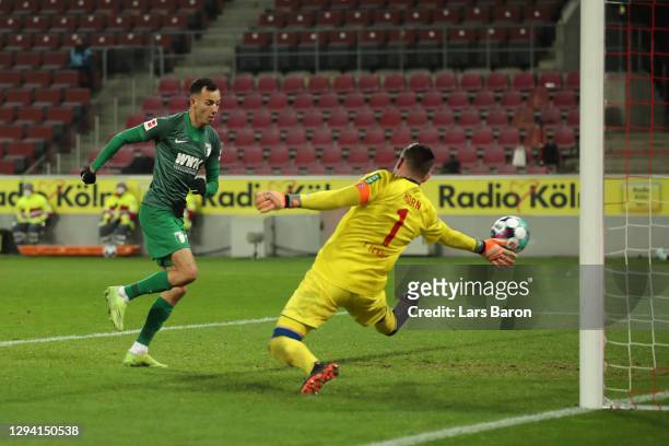 Iago of Augsburg scores his team's first goal against goalkeeper Timo Horn of Koeln during the Bundesliga match between 1. FC Koeln and FC Augsburg...
