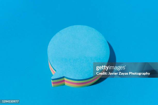 blue blank note in the shape of comic bubbles on blue background - colour icons business stockfoto's en -beelden