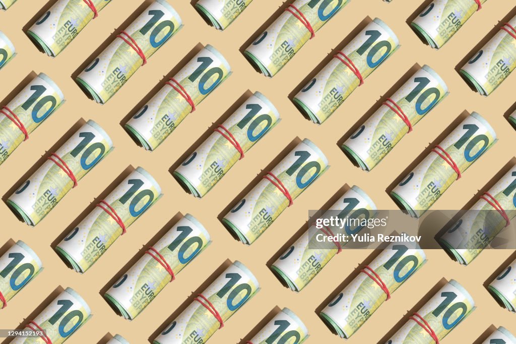Roll of 100 euro banknotes on the beige background