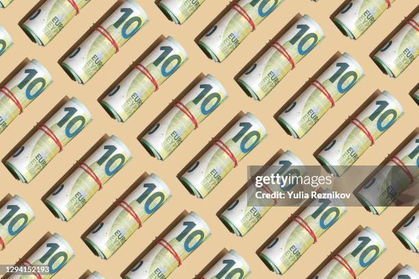 roll of 100 euro banknotes on the beige background - nota da comunidade europeia - fotografias e filmes do acervo