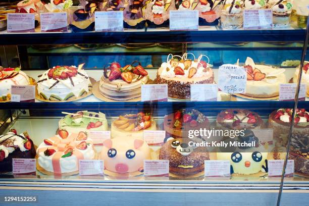 fun children cakes displayed in bakery shop window - cake sale stock-fotos und bilder