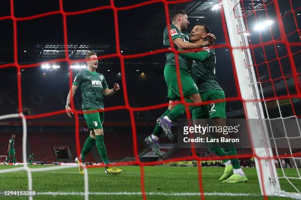 Iago of Augsburg celebrates his team's first goal with teammate Marco Richter during the Bundesliga match between 1. FC Koeln and FC Augsburg at...