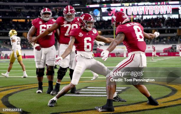 Wide receiver DeVonta Smith of the Alabama Crimson Tide celebrates his touchdown with teammate wide receiver John Metchie III in the first quarter of...