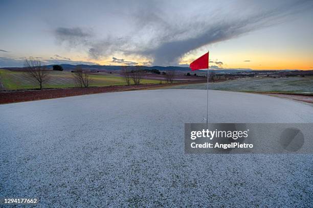 red flat in the snowed green - golf courtyad - green de golf stock-fotos und bilder