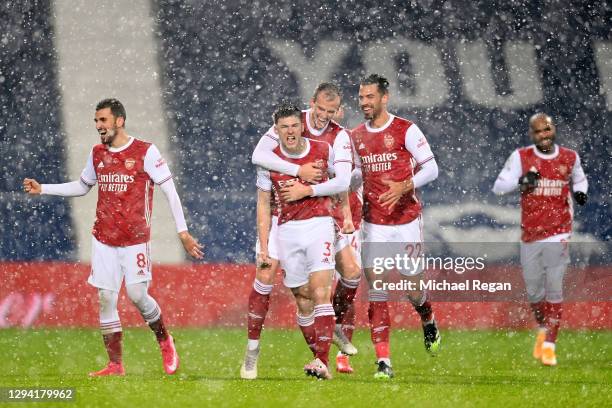 Kieran Tierney of Arsenal celebrates with teammates Rob Holding and Pablo Mari after scoring their team's first goal during the Premier League match...