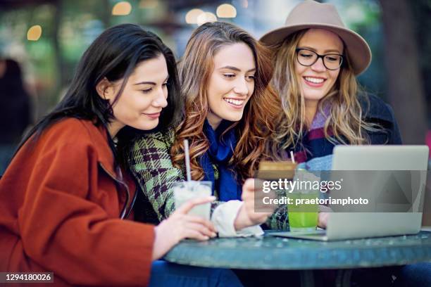 girlfriends are shopping online/making reservation in a cafe - cocktail counter stock pictures, royalty-free photos & images