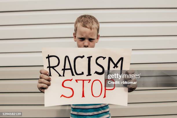 kid shows a poster with the inscription stop racism - kids placard stock pictures, royalty-free photos & images