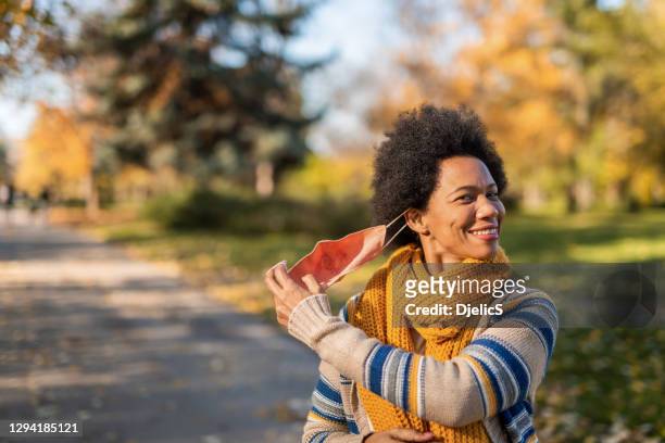 african american woman taking off face mask. - serbia covid stock pictures, royalty-free photos & images