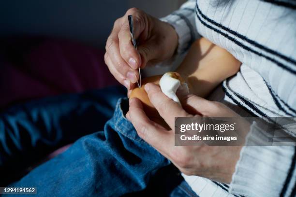 a mother's hands remove a splinter from a child's heel with tweezers - sliver stock pictures, royalty-free photos & images