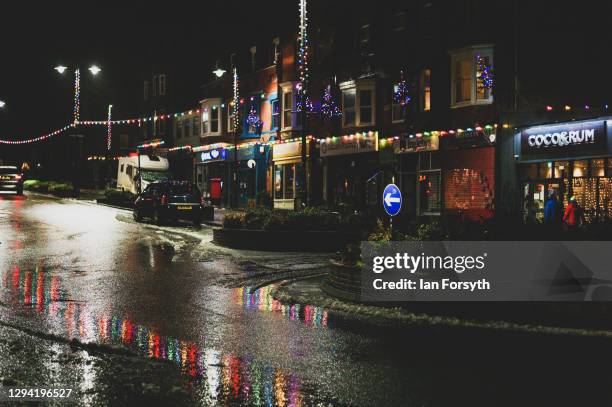 Christmas lights reflect off a wet road on a deserted street in Saltburn on January 02, 2021 in Saltburn By The Sea, England.