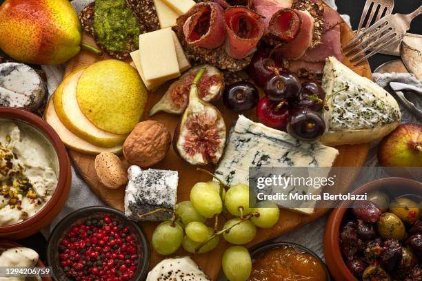 mix of antipasti cheese, prosciutto and fruits on platter - charcuterie stockfoto's en -beelden