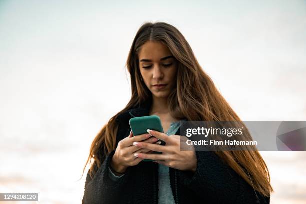 bad news on the phone young woman reading messages on mobile phone - mobile sad imagens e fotografias de stock