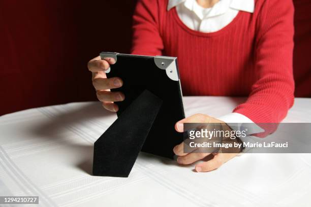 adult woman holding a picture frame - mourner stock pictures, royalty-free photos & images