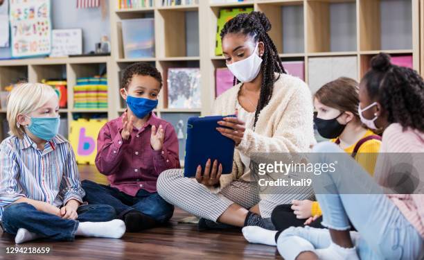preschool teacher, students in class, wearing masks - preschool stock pictures, royalty-free photos & images