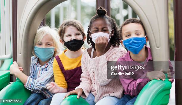 children on playground wearing face masks, covid-19 - playground stock pictures, royalty-free photos & images