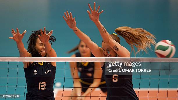 Sheila Castro and Thaisa Menezes try to block the ball during the preliminary match against Canada at the Pan American Vollyeball complex in the...