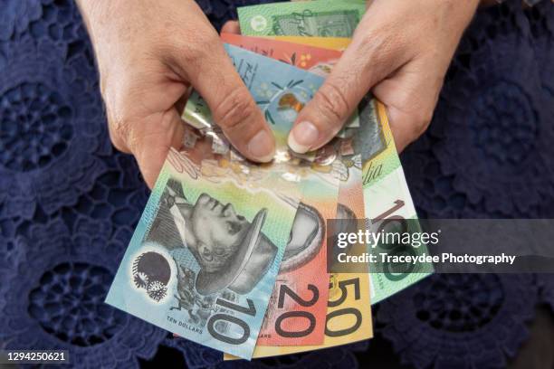 adult female holding some australian bank notes - fifty dollar bill stockfoto's en -beelden