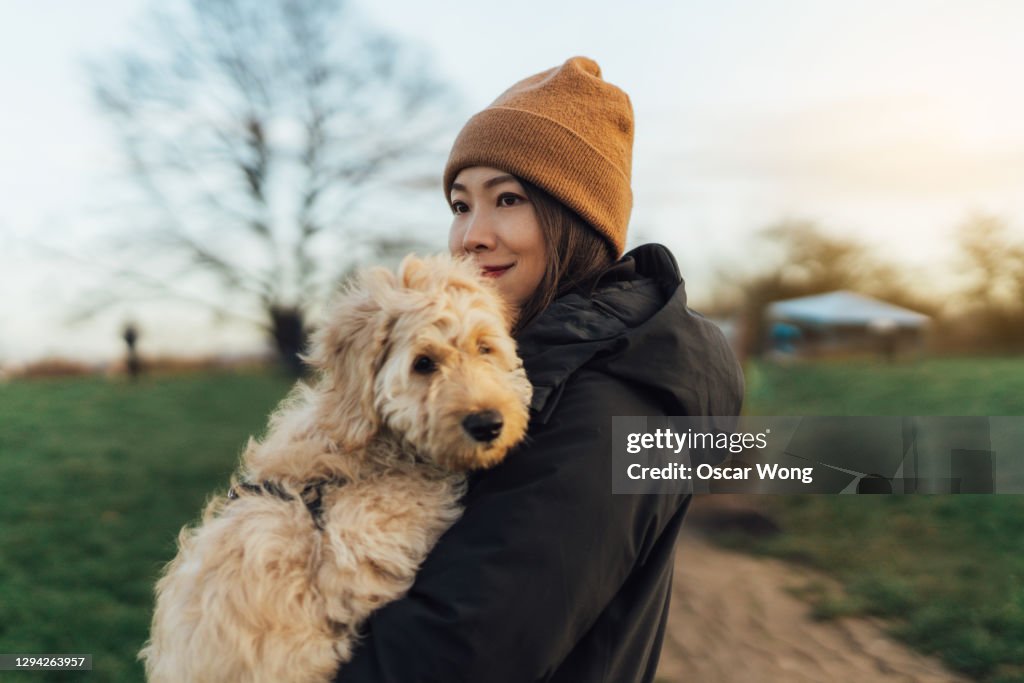 Young Woman Embracing Her Dog At The Park