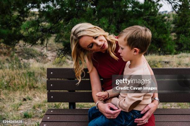 mother and young son sitting on a bench talking - elemntary stock pictures, royalty-free photos & images