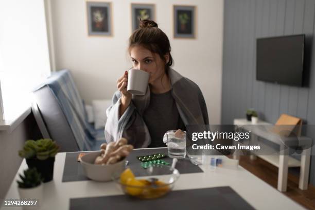 sick lady drinking warm tea - ginger tea stock pictures, royalty-free photos & images