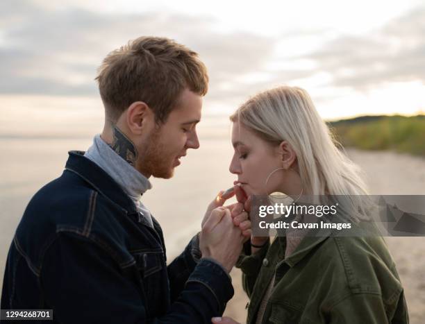crazy couple smoking weed in autumn countryside - marijuana tattoo stock pictures, royalty-free photos & images