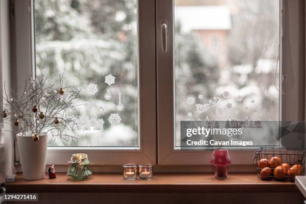 view of the window with snow-covered fir trees and christmas decor. - ledge stock pictures, royalty-free photos & images