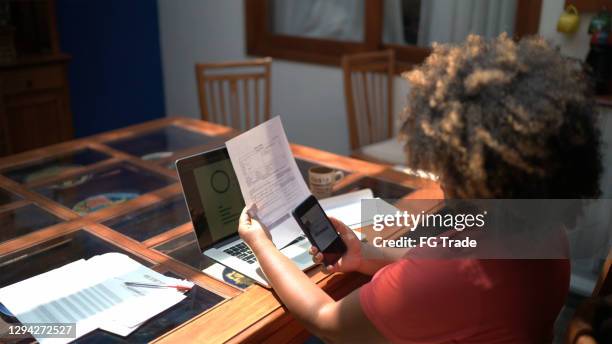 mature woman doing finances and working at home - scan barcode stock pictures, royalty-free photos & images