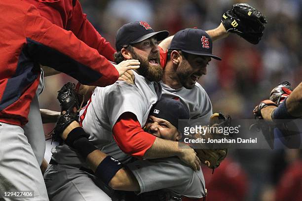 Jason Motte, Daniel Descalso and Yadier Molina of the St. Louis Cardinals celebrate after they won 12-6 against the Milwaukee Brewers during Game Six...
