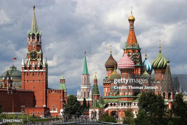 saint basil's cathedral and the moscow kremlin with dark clouds approaching - kremlin stock-fotos und bilder